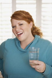 overweight woman smiling with a glass of water