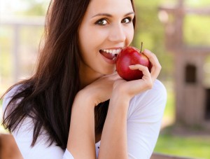 Young woman bites apple